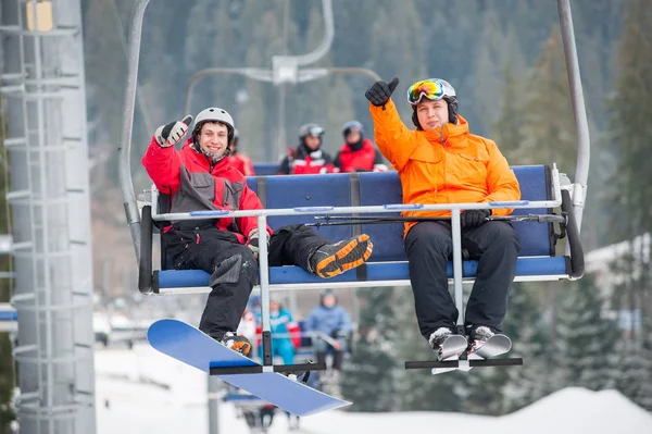 Skidåkare och snowboardåkare som rider på skidlift — Stockfoto