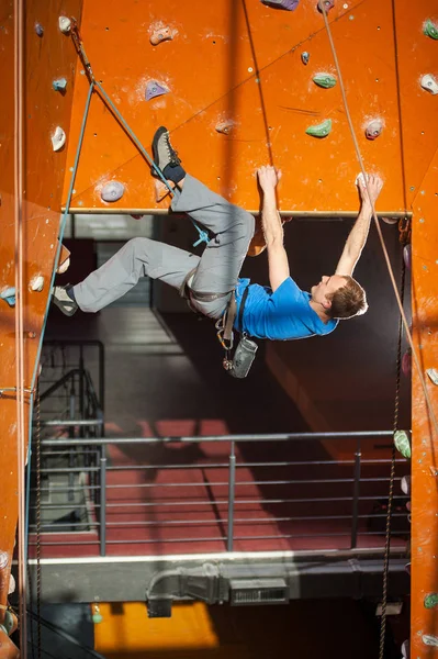 男性 rock-climber 屋内岩の壁でクライミングの練習 — ストック写真