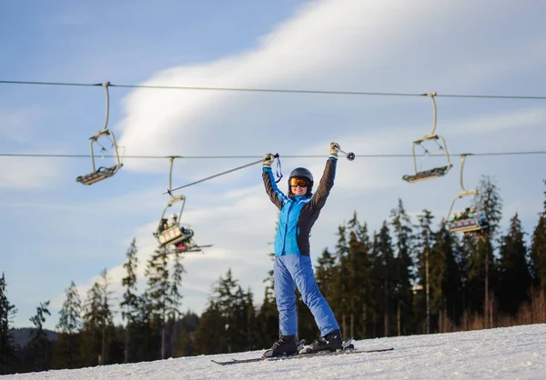 Teleferik ve güneşli bir orman karşı kadın kayakçı
