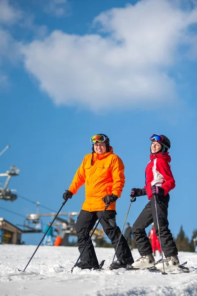 Man en vrouw skiër met ski's in winter resort — Stockfoto