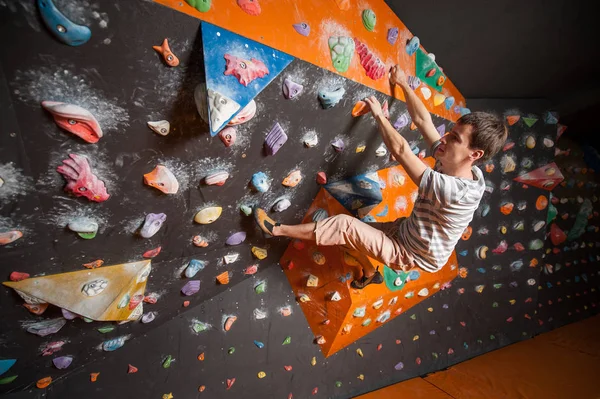 Forte alpinista macho na parede de escalada de pedregulho interior — Fotografia de Stock