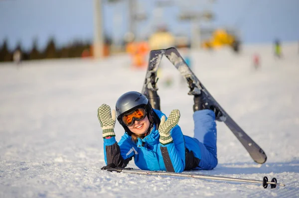 Jonge vrouw skiër na de val op de berghelling — Stockfoto