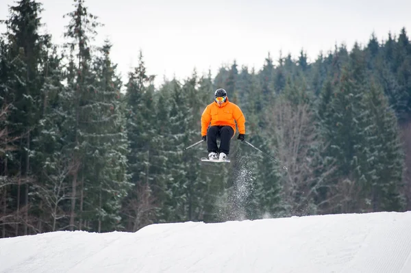 Sciatore al salto dal pendio delle montagne — Foto Stock