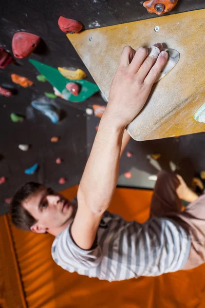 Сильный альпинист на каменной стене в помещении — стоковое фото