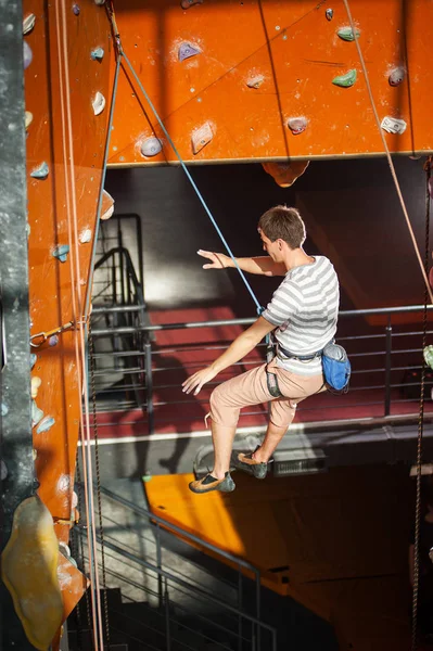 Homme escaladeur pratiquant l'escalade sur paroi rocheuse à l'intérieur — Photo