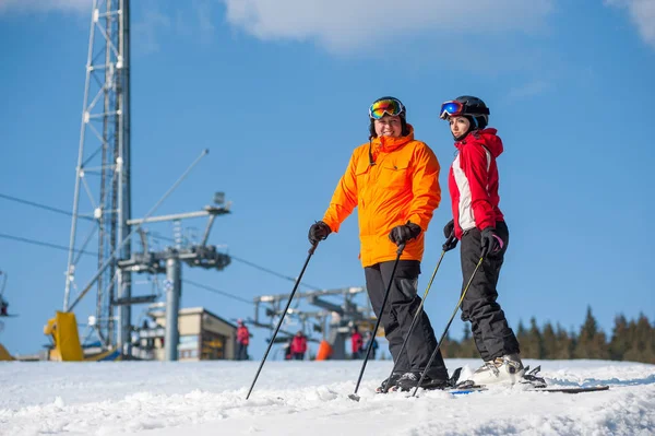 Man och kvinna skidåkare med skidor på vintern resort — Stockfoto