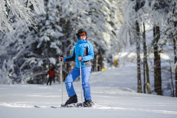 Mujer feliz esquiadora en una pista de esquí en el bosque —  Fotos de Stock