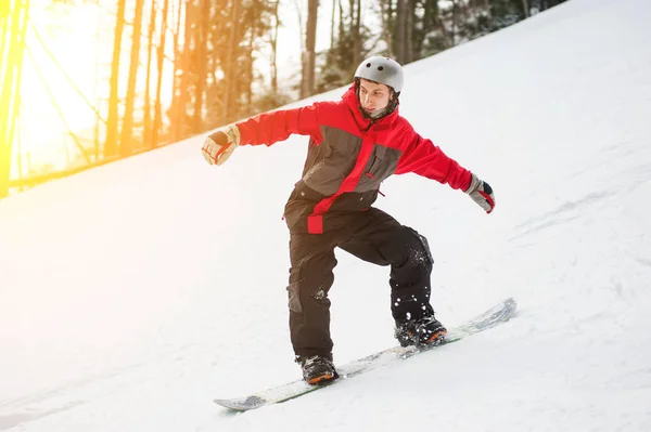 Mannelijke snowboarder dia's naar beneden uit de berg in de winterdag — Stockfoto