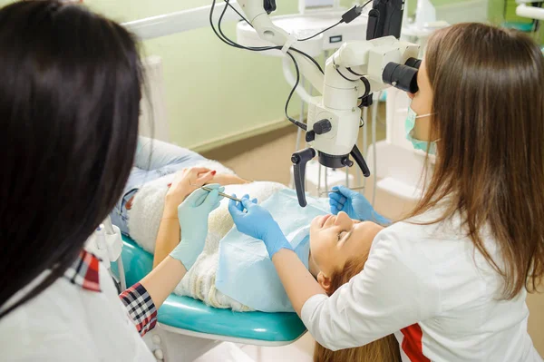 Zahnärztin behandelt Karies mikroskopisch in der Zahnarztpraxis — Stockfoto