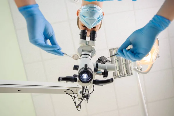 Läkare med ett Mikroskop i en tandvårdsklinik — Stockfoto