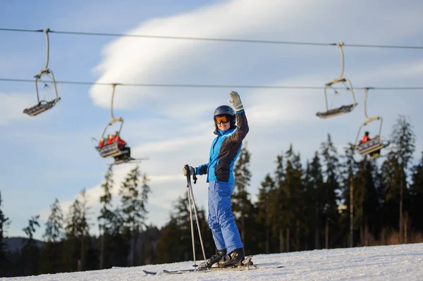 Kvinnliga skidåkare mot skidliften och skog på en solig dag — Stockfoto