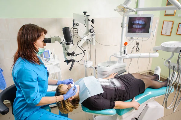 현대 치과 병원에서 현미경을 사용 하는 여성 치과 의사 — 스톡 사진