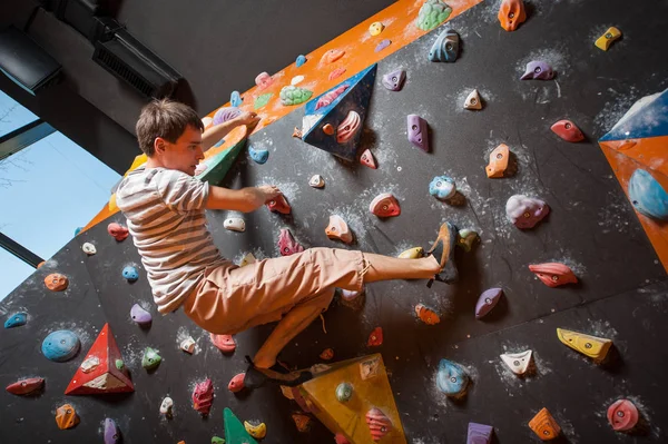 Forte alpinista macho na parede de escalada de pedregulho interior — Fotografia de Stock