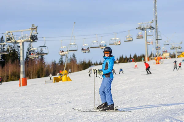 Kvinna skidåkare skidåkning nedför vid skidorten mot skidlift — Stockfoto