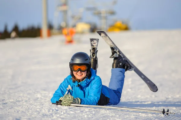 Ung kvinna skidåkare efter nedgången på bergssluttning — Stockfoto