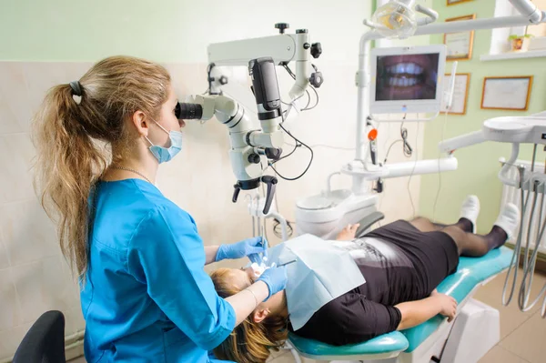 Zahnärztin arbeitet mit Mikroskop in moderner Zahnarztpraxis — Stockfoto