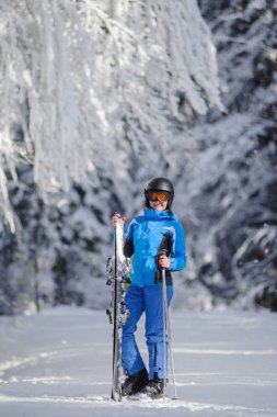Mutlu kadın kayakçı ormandaki bir kayak pisti üzerinde