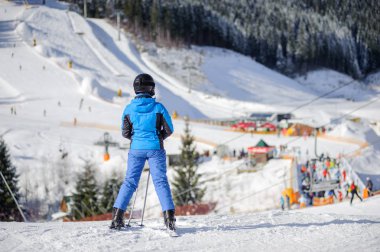Güneşli bir gün, bir kayak pisti üzerinde kadın kayakçı