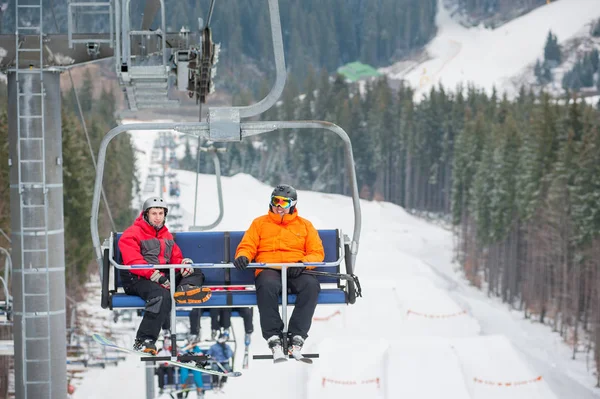 Skidåkare och snowboardåkare som rider på skidlift — Stockfoto