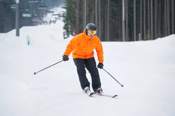 Skidåkare skidåkning nedför vid skidorten mot skidlift — Stockfoto