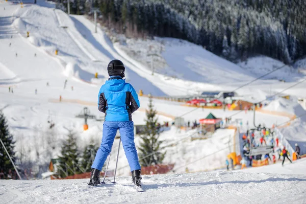 Esquiadora en una pista de esquí en un día soleado —  Fotos de Stock