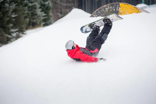 Snowboarder πέφτει στις πλαγιές κατά το άλμα — Φωτογραφία Αρχείου