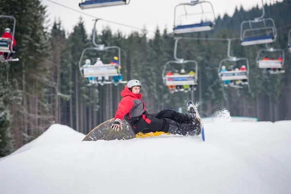 Snowboarder cai nas encostas durante o salto — Fotografia de Stock