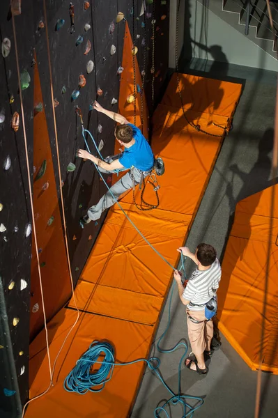 男性 rock-climber 屋内岩の壁でクライミングの練習 — ストック写真