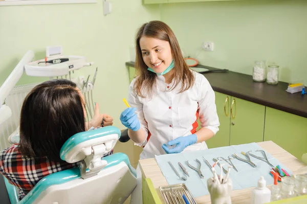 Odontóloga que trabaja en clínica dental con paciente femenina —  Fotos de Stock