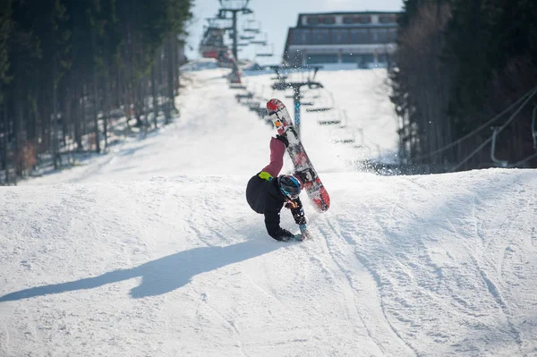 Snowboardåkare i ögonblicket av faller på snöiga backen — Stockfoto