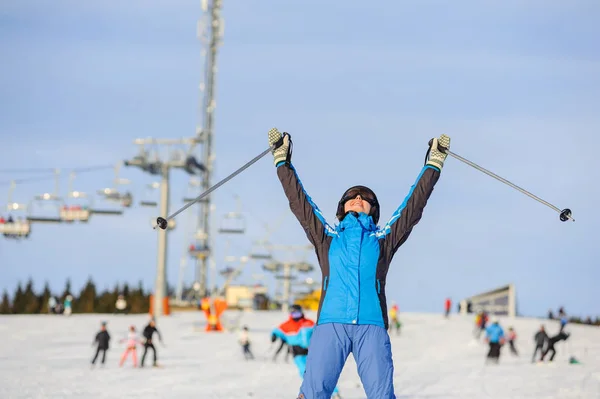 Kvinna skidåkare skidåkning nedför vid skidorten mot skidlift — Stockfoto