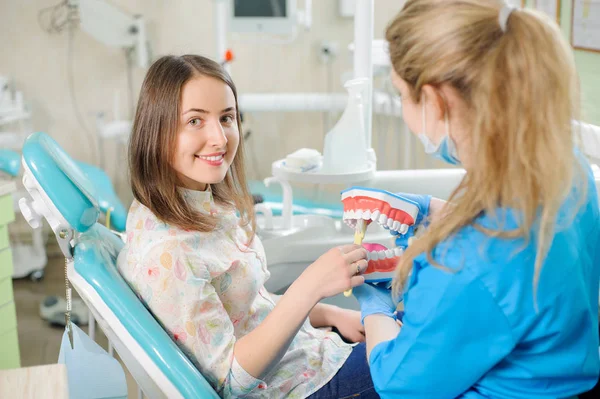 歯科医の診療所で患者に歯科医示す歯科顎モデル — ストック写真
