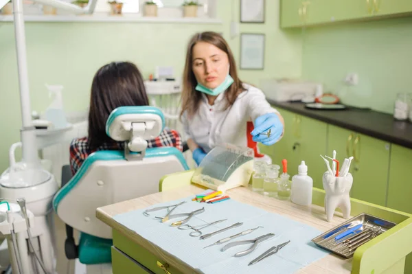 Жінка-стоматолог, що працює в стоматологічній клініці з патентом жінки — стокове фото