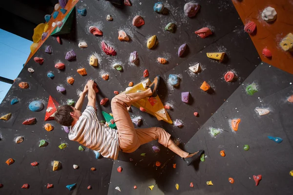 Starker männlicher Kletterer an Boulderkletterwand im Innenbereich — Stockfoto