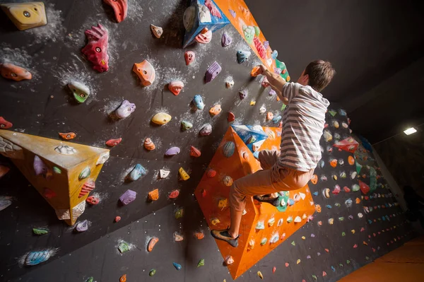 Strong male climber on boulder climbing wall indoor — Stock Photo, Image