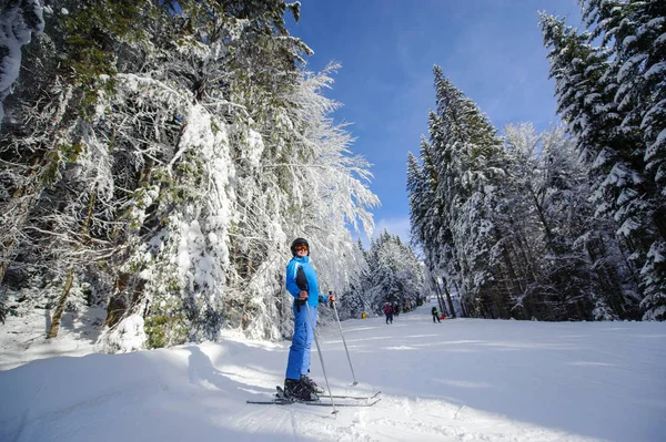 Gelukkige vrouw skiër op een skihelling in het bos — Stockfoto