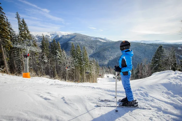 Female skier against ski-lift and winter mountains background — Stock Photo, Image