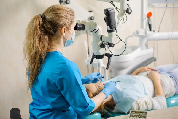 Zahnärztin behandelt Karies mikroskopisch in der Zahnarztpraxis — Stockfoto