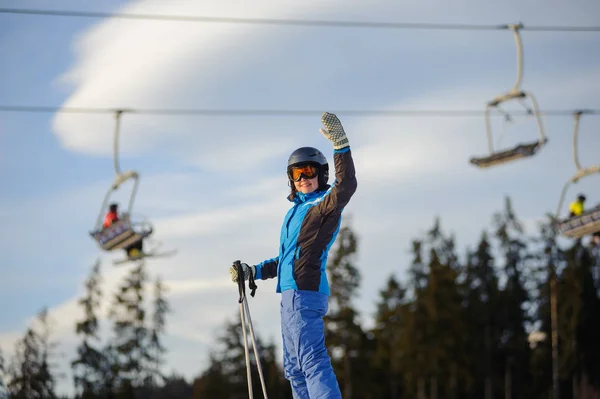 女子滑雪运动员对滑雪缆车和森林在阳光明媚的一天 — 图库照片