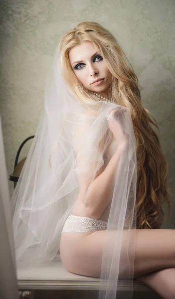 Gyönyörű menyasszony visel fátylat és fehérnemű esküvő napján — Stock Fotó