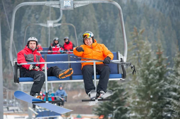 Sciatore e snowboarder in sella agli impianti di risalita — Foto Stock