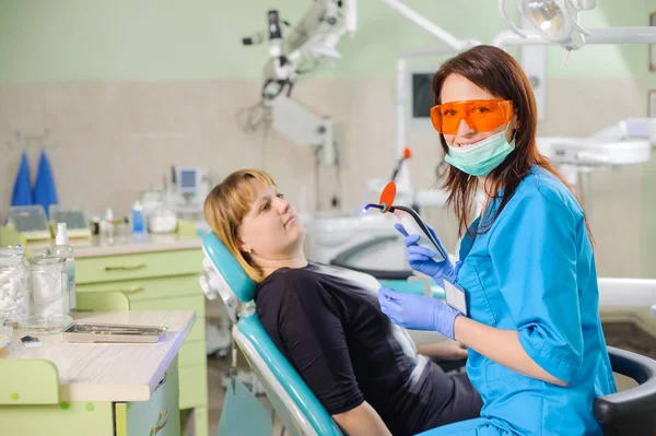 Dentista femenina con lámpara fotopolímero de dentista — Foto de Stock