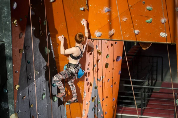 Kobiece wspinacz jest wspinaczka na kryty ścianka — Zdjęcie stockowe
