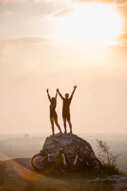 Dağ bisikleti yakınındaki büyük bir taş üzerinde duran bisikletçiler