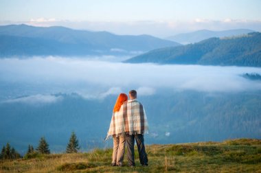 Çift büyüleyici bir sabah sis Dağların üzerinden zevk bir tepe üzerinde bir ekose ayakta kaplı. Arkadan görünüş