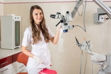 Modern diş hekimi office mikroskobu ile çekici kadın doktor