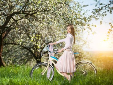 Bahar bahçe retro bisiklet ile güzel kadın bisikletçi