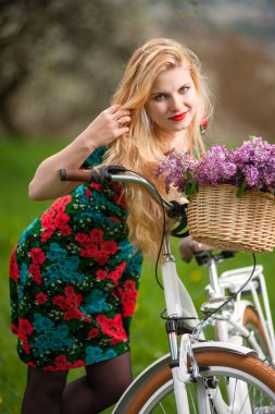 Çiçek sepeti ile vintage beyaz bisiklet ile kız