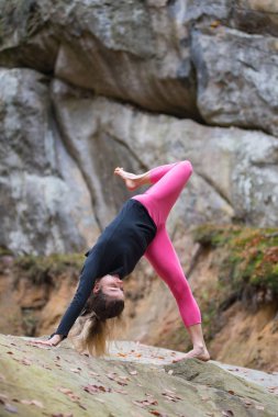Sportif uygun kadın kaya doğada yoga pratik