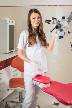 Modern diş hekimi office mikroskobu ile çekici kadın doktor